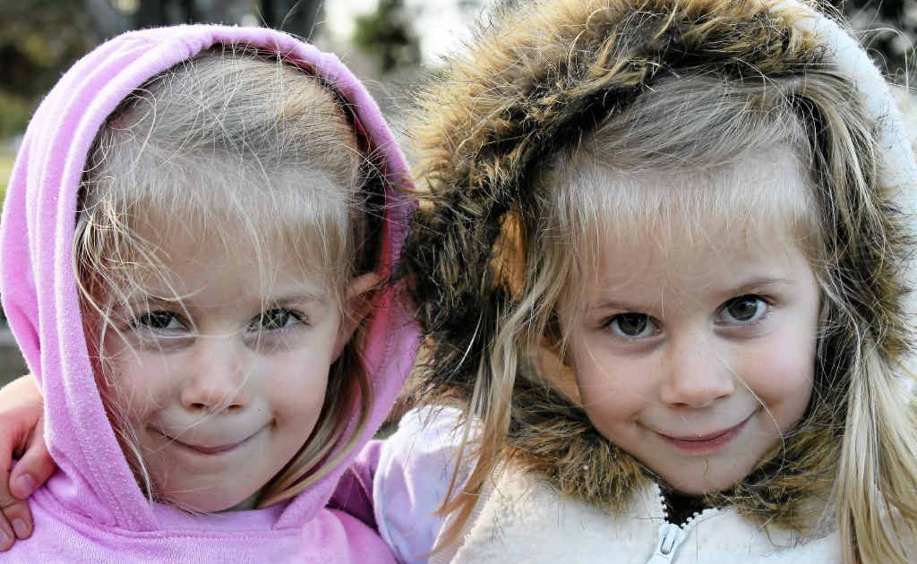 Twins Hannah and Abby Moody stay rugged up while playing in the park.